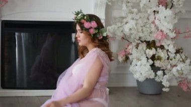 Çiçek baş çelenk silit şömine yakın yerdeki genç bir hamile kadın