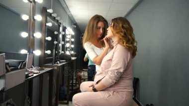 Allık makyaj fırça ile genç kadın elmacık için uygulamak.