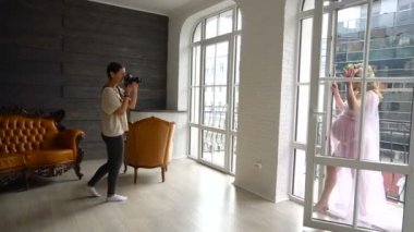 Büyük pencere ayakta hamile genç kadın fotoğrafçı alarak resim.