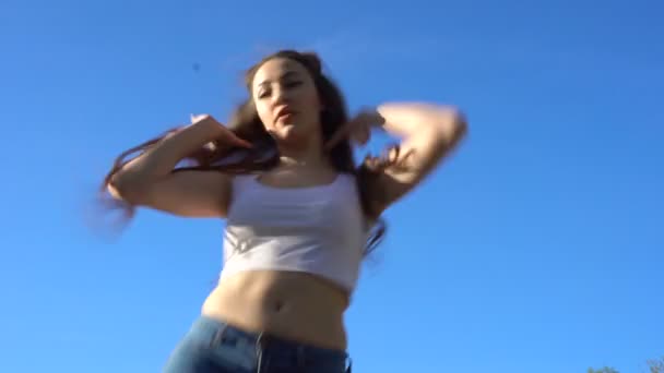 Μοντέλο κορίτσι που χορεύει μπροστά από το μπλε του ουρανού — Αρχείο Βίντεο
