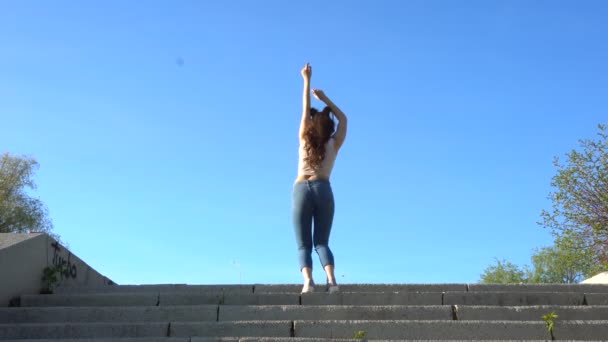 Vista trasera de la chica elegante bailando en las escaleras — Vídeos de Stock