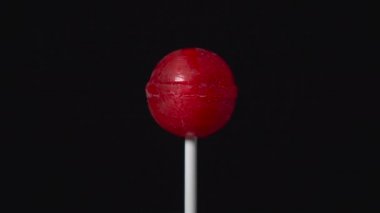 plastik çubuk üzerinde lolipop döndürme Ball siyah arka plan üzerine form olarak