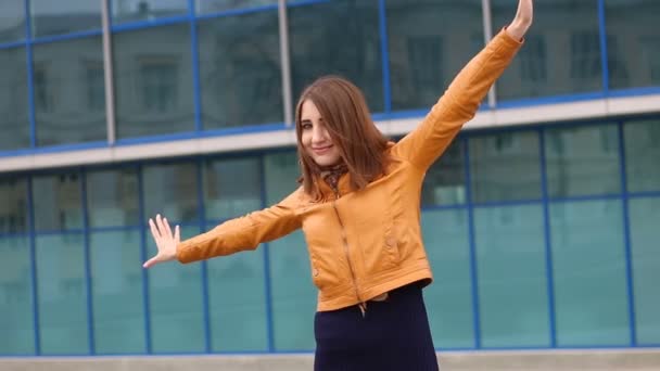Счастливая женщина поднимает руки на городской пейзаж, обнимает город, ветер, расслабиться — стоковое видео