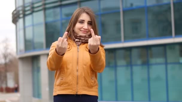 Heel mooi meisje maakt obsceen handgebaar door toont middelvinger in de stad buiten. — Stockvideo