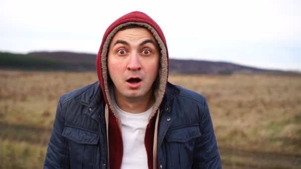 Headshot d'un homme étonné portant une capuche en plein air — Video