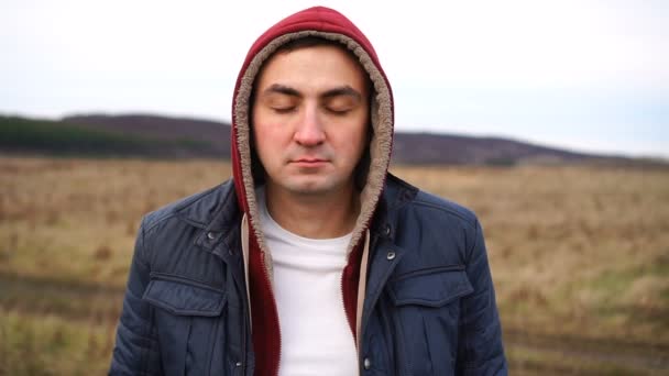 Calm portrait of man in hood who standing with closed eyes — Stock Video