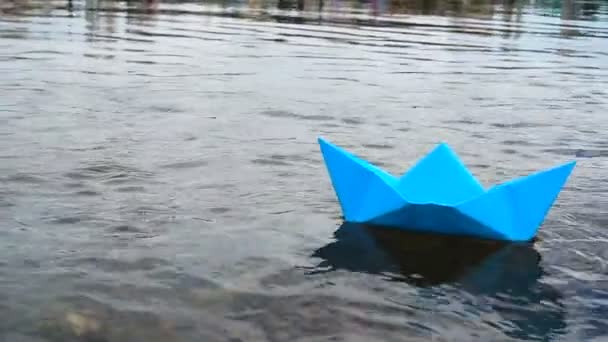 Blue paper boat sailing on water on romantic sunset. Origami — Stock Video