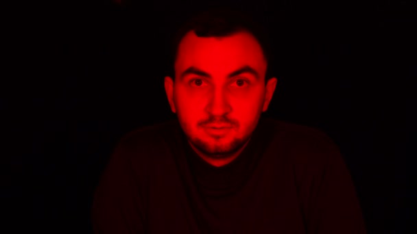 Man Face in Dark, with Red Glowing Light, Facial Expressions. Portrait of Devil, Scary Concept — Stock Video