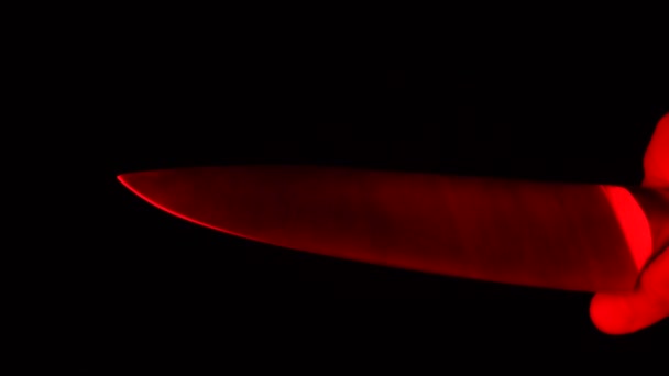 Жахлива сцена чоловічої руки з ножем на червоному сяючому світлі. Послідовний вбивця або концепція насильства — стокове відео