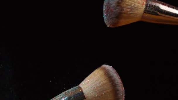 Makeup brush with colorful powder splashes explosion on black background — Stock Video