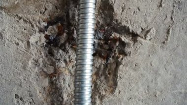 Kabloları korumak için gri kıvrımlı metal kablo kanalı. Onarım veya inşaat konsepti