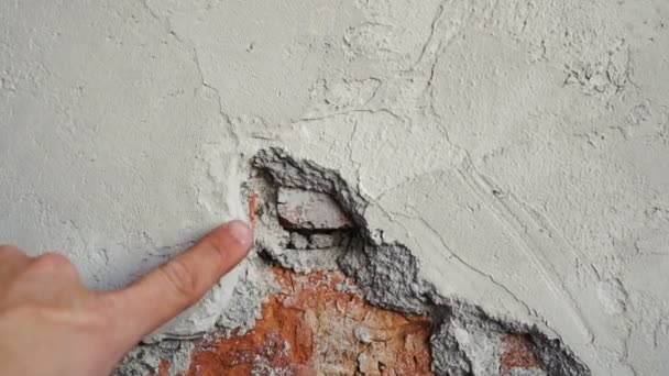 Hand points to cement in brick wall — Stockvideo