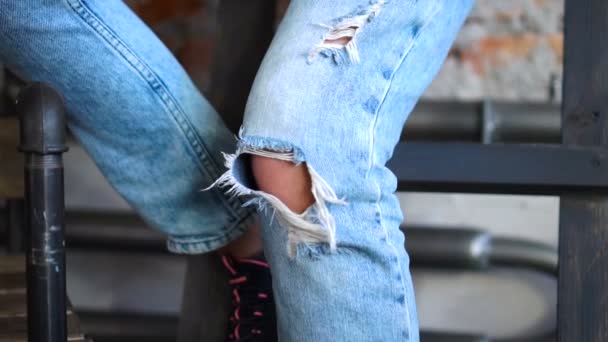 Jeans strappati su uno sfondo di una parete di mattoni. Stile di moda — Video Stock