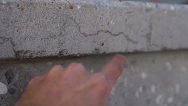 Hand points to crack in concrete wall — Stock Video