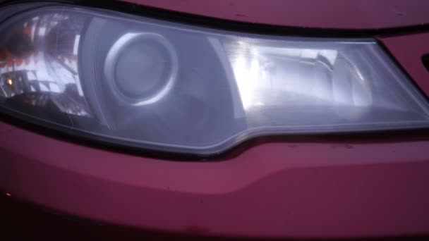 Red car headlight turning on and off. Close-up of details of headlights — Stock Video