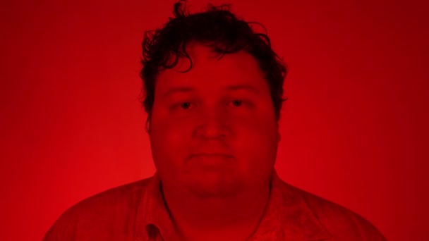 Portrait d'homme debout dans une pièce avec éclairage rouge — Video
