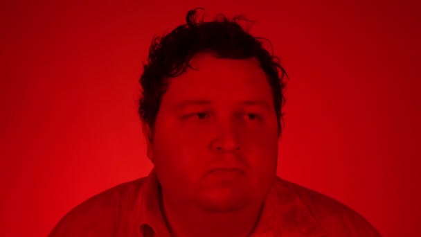 Hombre gordo bailando aislado sobre fondo rojo. Retrato con iluminación roja — Vídeo de stock