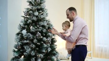 Baba ve küçük kızı Noel ağacının yanında kollarında. Aile ve babalık