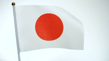 Japon bayrağı bayrak direğinde dalgalanıyor ve rüzgarda dalgalanıyor.