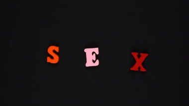 Kelime seksi, ahşap renkli harflerden oluşur. Renkli kelimeler dönüyor. Hareketi durdur
