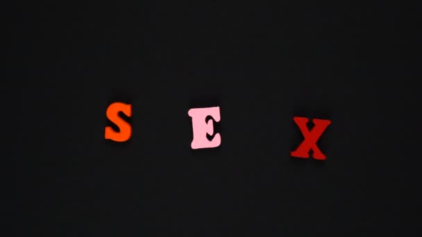 Word sex formed of wooden multicolored letters. Colorful words loop. Stop motion animation — Stock Video