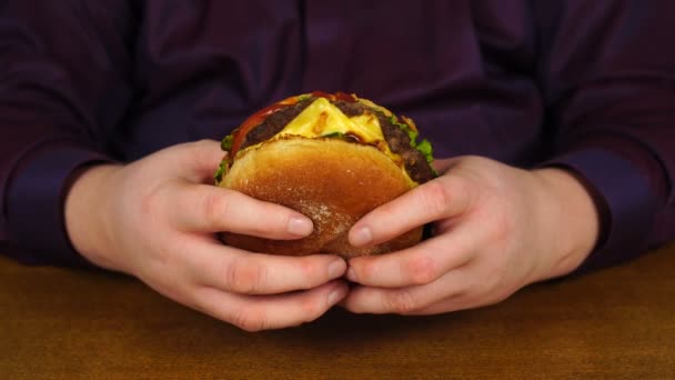 Hombre sosteniendo hamburguesa a la parrilla recién preparada — Vídeos de Stock