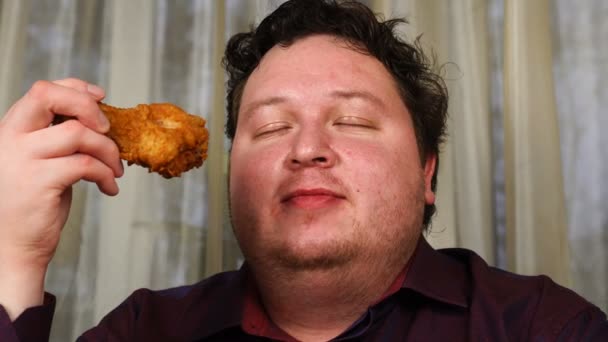 Young handsome man sniffing a chicken drumstick — Stok video