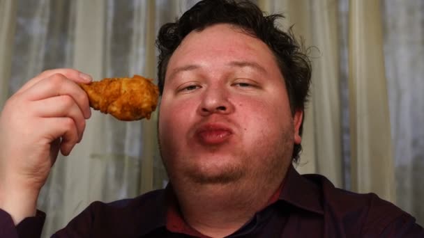 Jeune homme beau mangeant un pilon de poulet — Video