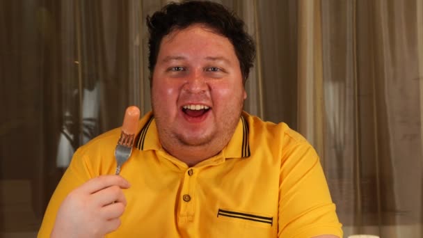 Mężczyzna trzymający kiełbasę ze szczęśliwą twarzą. Jedzenie śniadania gospodarstwa hot dog — Wideo stockowe