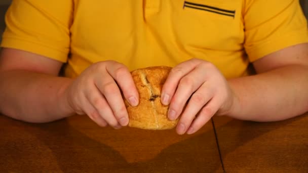 Mens händer bryter en croissant. Choklad flödar inte från två halvor av en croissant — Stockvideo