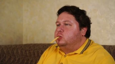 Overweight person who spoiled healthy food by eating french fries. Diet failure of fat man eating fast food.