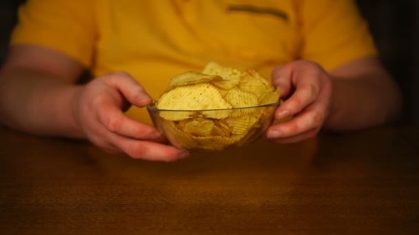 Oigenkännlig man håller tallrik chips i sina händer — Stockvideo