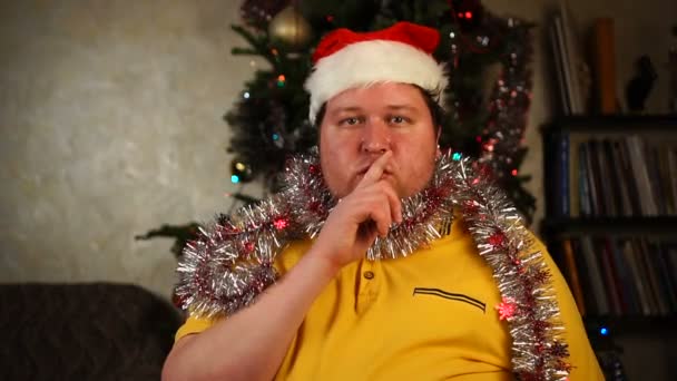 Homem de chapéu de Santa e ouropel fazendo gesto de silêncio — Vídeo de Stock