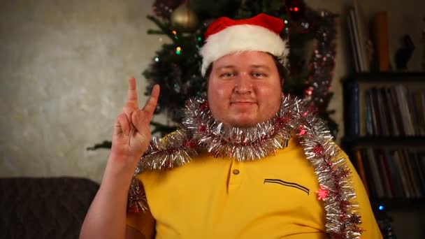 Man met kerstmuts en knutsel met overwinningsteken — Stockvideo
