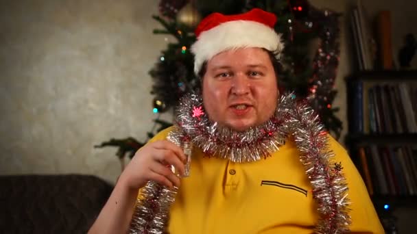 Man met kerstmuts drinkt een glas wodka. — Stockvideo
