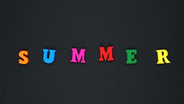 Слово "літо" складається з дерев'яних різнокольорових літер. Барвисті слова цикл . — стокове відео