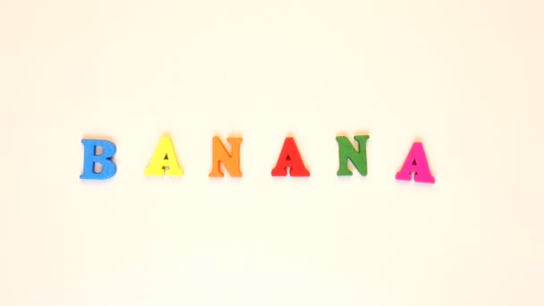 Palavra "banana" formada de letras multicoloridas de madeira. Laço de palavras coloridas . — Vídeo de Stock