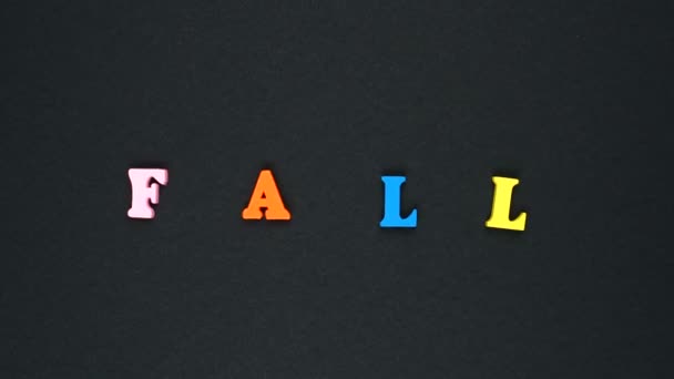 Слово "падіння" утворюється з дерев'яних різнокольорових літер. Барвисті слова цикл . — стокове відео