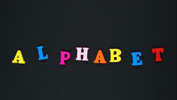 Слово "алфавіт" складається з дерев'яних різнокольорових літер. Барвисті слова цикл . — стокове відео