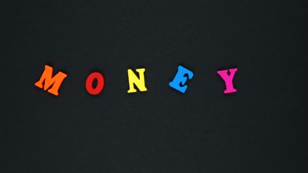 Palabra "dinero" formada por letras multicolores de madera. Lazo de palabras coloridas . — Vídeos de Stock
