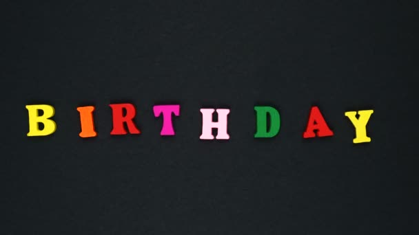 Word "birthday" formed of wooden multicolored letters. Colorful words loop. — Stock videók