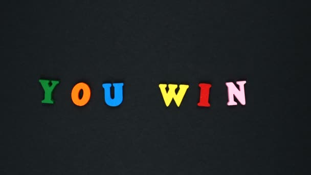 Word "you win" formed of wooden multicolored letters. Colorful words loop. — Stock video