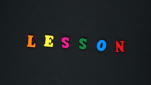 Word "lesson" formed of wooden multicolored letters. Colorful words loop. — Stok video