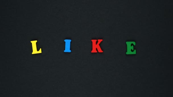 Word "like" formed of wooden multicolored letters. Colorful words loop. — Stock video