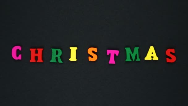 Слово "різдвяні" складається з дерев'яних різнокольорових літер. Барвисті слова цикл . — стокове відео