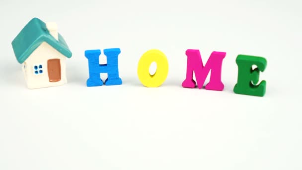 Dekorativní písmena tvořící slovo HOME s domem na bílém pozadí — Stock video