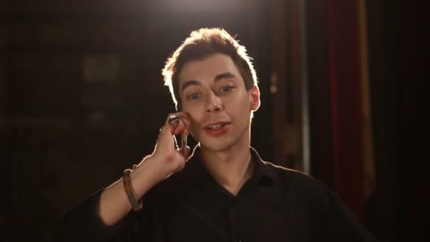 Knappe man praten telefoon tegen achtergrond achtergrondverlichting — Stockvideo