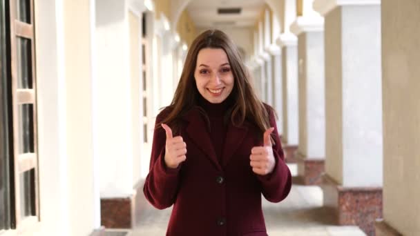 La fille en manteau regarde la caméra, hoche la tête et dit oui — Video