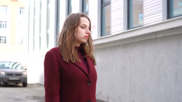 Приваблива дівчина, що йде по міській вулиці — стокове відео