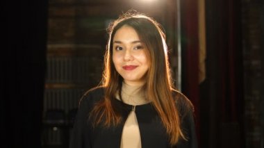 Güzel kız göz kırpıyor, gülümsüyor ve kameraya bakıyor.